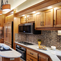 Custom RV kitchen from New Horizons with oak cabinets and large l shaped counter