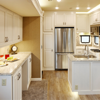 Custom RV kitchen from New Horizons with all white cabinets and buffet counter along wall