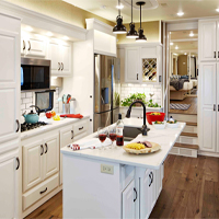 Custom RV kitchen from New Horizons with all white cabinets and tops and center island with counter seating