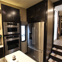 Custom RV kitchen from New Horizons with stainless steel appliances and dual ovens